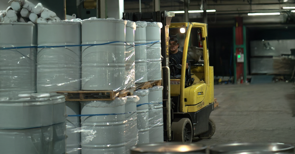 Forklift moving 55-gallon steel drums