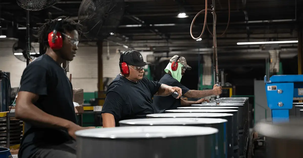NCC team members on the production line manufacturing steel drums