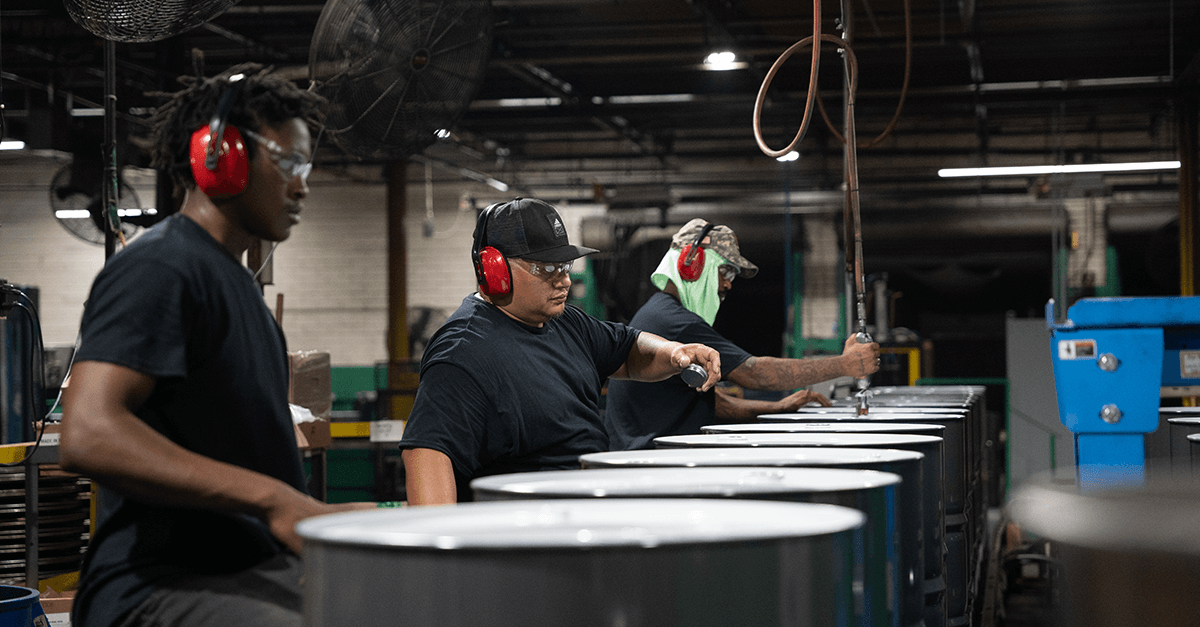NCC team members on the production line manufacturing steel drums