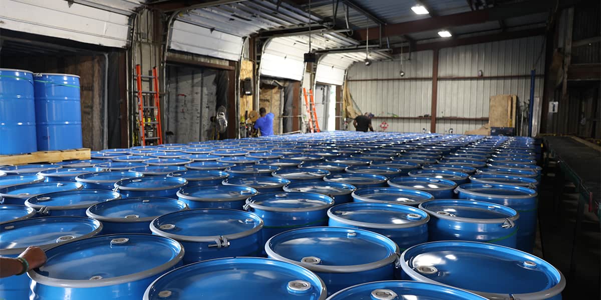 Rows of 55 gallon steel drums staged for delivery inside a North Coast Container facility
